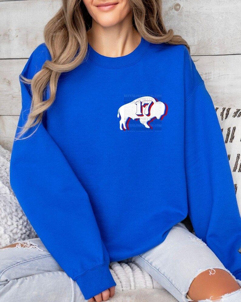May include: Royal blue sweatshirt with a white buffalo silhouette and the number 17 in red and white. The buffalo is outlined in red and has a white outline around the number 17.