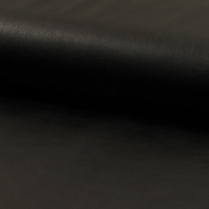 Könnte beinhalten: Nahaufnahme eines schwarzen Lederstoffs mit glatter Textur.