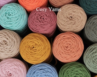 Könnte beinhalten: Eine Sammlung mehrerer Garnrollen in verschiedenen Farben wie Orange, Pink, Blau, Grün, Gelb und Braun, die in einem Raster angeordnet sind. Der Text "Cosy Yarns" ist in Weiß in der Mitte des Bildes über den Garnrollen aufgedruckt.