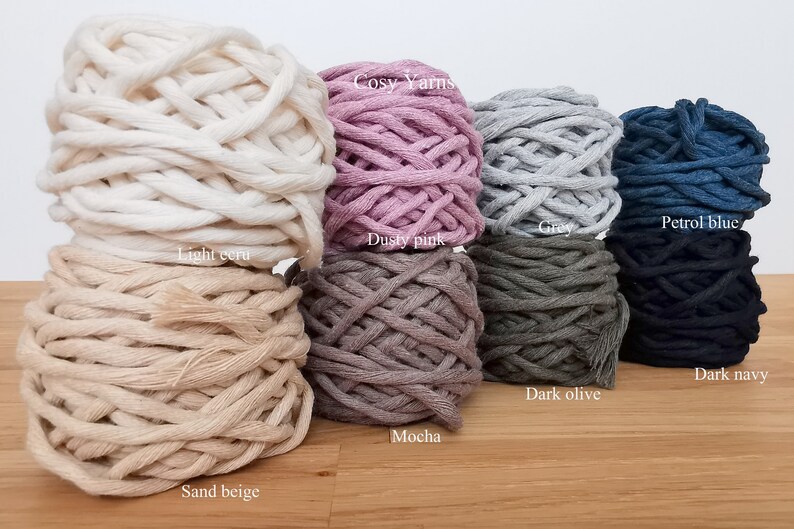 May include: Assortment of 10 balls of cotton rope yarn in various colors, including light ecru, sand beige, dusty pink, mocha, gray, dark olive, petrol blue, and dark navy. The yarn is labeled "Cosy Yarns".