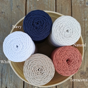 May include: Five spools of cotton rope in a wooden bowl. The colours are navy, white, beige, natural, and terracotta.