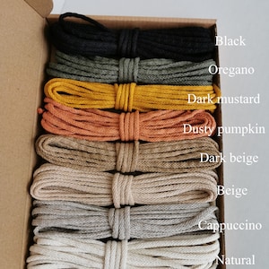 May include: A box containing 10 spools of cotton cord in a variety of colours, including black, oregano, dark mustard, dusty pumpkin, dark beige, beige, cappuccino, and natural. The box is labelled "Mix A".