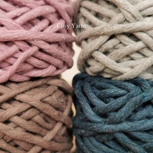 K&ouml;nnte beinhalten: Vier Kn&auml;uel Garn in verschiedenen Farben: staubiges Rosa, Mokka, Grau und Petrolblau. Das Garn ist mit "Cosy Yarns" gekennzeichnet.