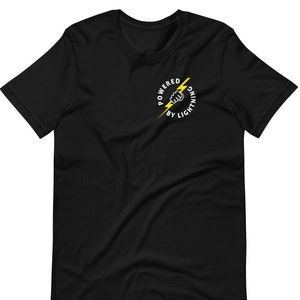 Puede incluir: Camiseta negra con un rayo amarillo y un puño gráfico. El gráfico está en un círculo con el texto "Powered by Lightning".