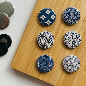 Könnte beinhalten: Sechs runde, blau-weiße Knöpfe mit verschiedenen japanisch inspirierten Designs.