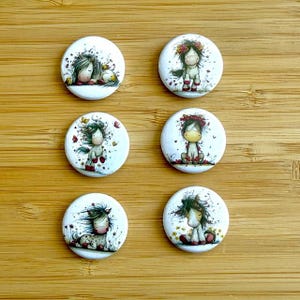 Op de afbeelding: Zes witte, ronde knopen met illustraties van grillige paarden. Elke knoop heeft een ander paardenontwerp, met bloemaccenten en zachte kleurenpaletten. De knopen zijn gerangschikt op een houten oppervlak.