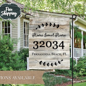 May include: A wooden garden flag with a rustic woodgrain design. The flag features the text "Home Sweet Home" and the house number "32034". The text "Fernandina Beach, FL" is also included on the flag.