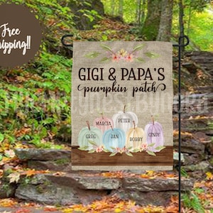 Puede incluir: Una bandera de jardín de arpillera con el texto "Gigi & Papa's pumpkin patch" en letras marrones. La bandera presenta una fila de seis calabazas de color pastel con nombres escritos en cada calabaza: Greg, Marcia, Jan, Peter, Bobby y Cindy.