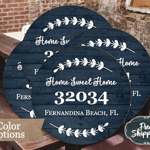Op de afbeelding: Vier ronde houten borden met een donkerblauwe achtergrond en witte tekst. De borden hebben een bladmotief en de tekst "Home Sweet Home", "Fernandina Beach, FL", "32034" en "Home".
