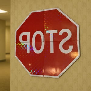 May include: An octagonal red sign with a white border and the white text POTS printed in a mirrored, reversed orientation. The surface of the sign features a reflective, holographic diamond pattern that catches light across its four segments.