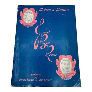 May include: A blue program for "The Jewel Box Revue" produced by Danny Brown and Doc Brenner. The program features a pink cursive script logo and portraits of Danny Brown and Doc Brenner.