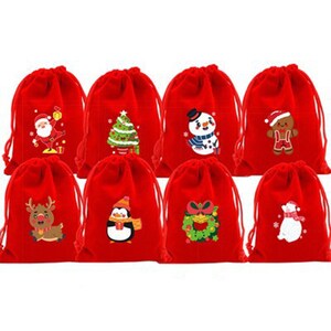 May include: Eight red drawstring gift bags with various Christmas-themed designs. Each bag features a different festive graphic, including Santa Claus, a Christmas tree, a snowman, a gingerbread man, a reindeer, a penguin, a wreath, and a polar bear.