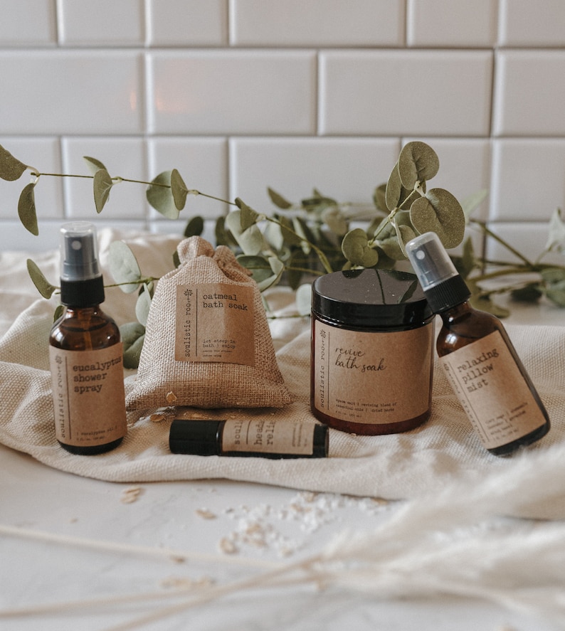 K&ouml;nnte beinhalten: Ein Set an Bad- und K&ouml;rperprodukten, bestehend aus einer braunen Glasflasche mit Spr&uuml;hkopf, beschriftet mit "eucalyptus shower spray", einem kleinen Jutesack mit der Aufschrift "oatmeal bath soak", einer braunen Glasflasche mit Spr&uuml;hkopf, beschriftet mit "relaxing pillow mist", einem Glasgef&auml;&szlig; mit der Aufschrift "revive bath soak" und einer kleinen braunen Glasrollflasche mit der Aufschrift "head relief".
