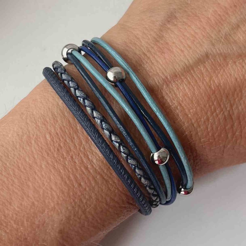 May include: A multi-layered bracelet with blue and gray leather straps and silver beads.
