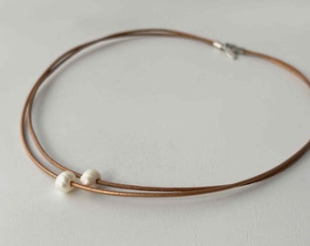 short necklace made of leather straps with 2 brown beads