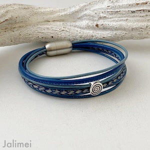 May include: A multi-layered blue leather bracelet with a silver magnetic clasp and a silver spiral charm.