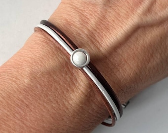 Pulsera fina de cuero marrón con una piedra blanca