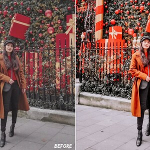 May include: A woman wearing a brown coat, black pants, and a black hat stands in front of a Christmas tree decorated with red ornaments and presents. The tree is behind a black metal fence.