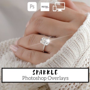 May include: A close-up of a hand wearing a ring with a large, sparkling, cushion-cut diamond. The ring is set in a simple, silver band. The hand is resting on a white, knitted fabric. The text "SPARKLE Photoshop Overlays" is displayed below the image.