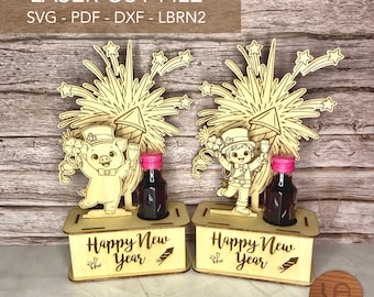 May include: Laser-cut wooden New Year's Eve decorations. Each features a cartoon character, fireworks, and a bottle with a pink cap. The base reads "Happy New Year". The design is suitable for laser cutting.