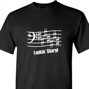 Puede incluir: Camiseta negra con una nota musical blanca y el texto "Lookin' Sharp!"