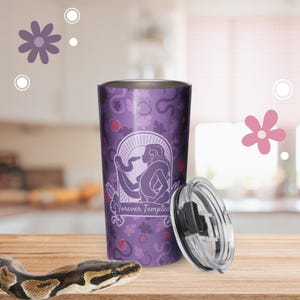 May include: A purple stainless steel tumbler featuring a graphic of a figure with a snake and the text Forever Tempted. The tumbler has a repeating pattern of leaves and apples, and includes a clear plastic lid with a black sliding closure.