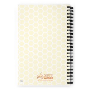 A spiral-bound notebook with a pale yellow honeycomb pattern cover and the Fatty Pancake logo near the center bottom. The notebook is displayed on a bright white background.