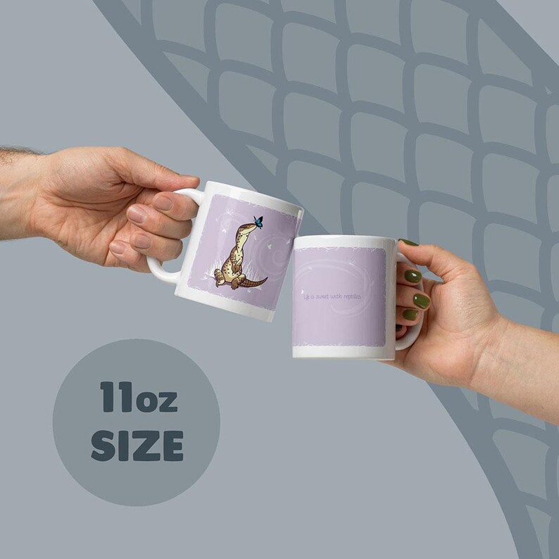 May include: Two white 11oz ceramic mugs with a light purple background. One mug features a brown lizard with a blue butterfly on its nose. The other mug displays the text 'Life is sweet with reptile' in a simple font. Both mugs have a handle.