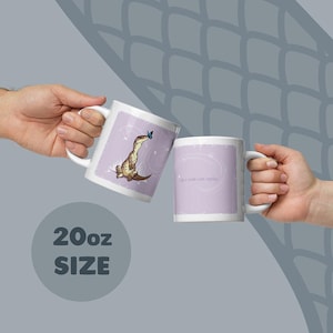 May include: Two white 20oz ceramic mugs with a light purple rectangular graphic. One mug features a brown spotted lizard looking at a blue butterfly. The other mug displays faint white text on a light purple background with a swirling design.