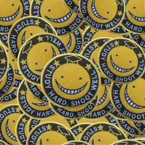 Puede incluir: Primer plano de varios parches bordados amarillos y negros con el texto "Study Hard, Shoot Well" y una cara sonriente con un gorro de graduación.