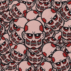 May include: A close-up of a pile of pink and red embroidered patches featuring a cartoon face with a menacing expression. The patches are all identical and feature a black outline.