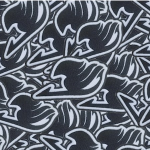 May include: A close-up of a pile of black and white fabric patches with a stylized wave design. The patches are arranged in a random pattern.