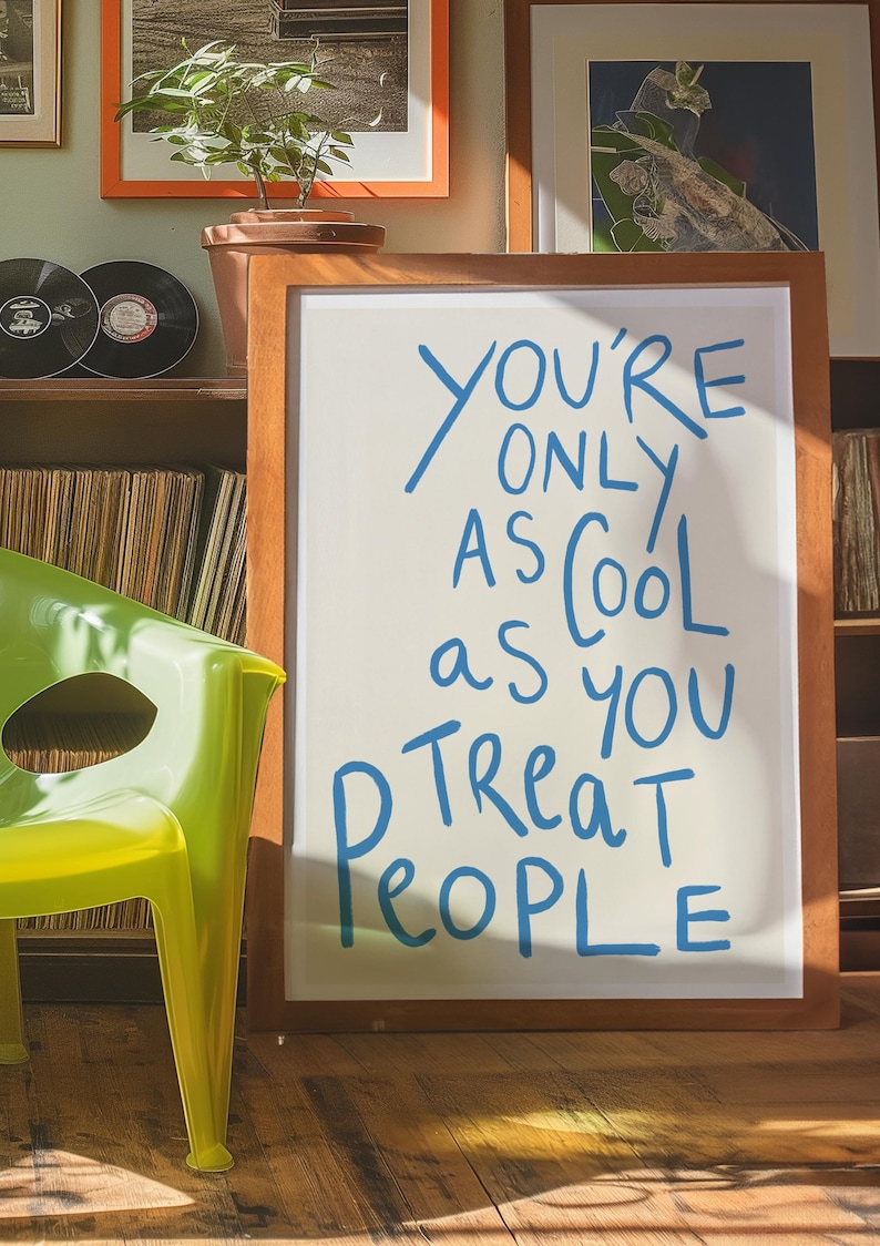 May include: A wooden framed sign with a white background and blue lettering that reads "You're only as cool as you treat people".