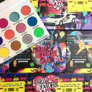 Könnte beinhalten: Eine Make-up-Palette mit 12 bunten Lidschatten, darunter Lila, Blau, Grün und Gelb. Die Palette wird mit mehreren Boxen mit Retro-Designs, darunter eine Kassette und ein Sportwagen, präsentiert. Der Text "REBEL ROHC LABS" ist sichtbar.