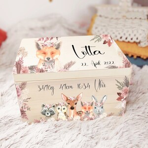 K&ouml;nnte beinhalten: Eine h&ouml;lzerne Erinnerungsbox mit einem Blumendesign, das einen Fuchs, ein Reh, eine Eule, einen Waschb&auml;r und ein Kaninchen zeigt. Die Box ist personalisiert mit dem Namen "Lotta", dem Datum "22. April 2022" und der Uhrzeit "16:34 Uhr". Die Box enth&auml;lt auch die Ma&szlig;e "3410g" und "49cm".