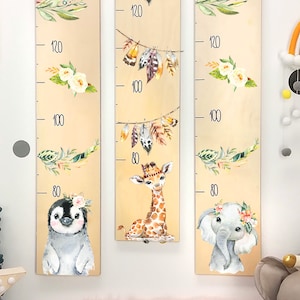 May include: Three wooden growth charts with animal illustrations. The left chart features a penguin, the middle chart features a giraffe, and the right chart features an elephant. Each chart has a floral design and a height measurement scale in inches.
