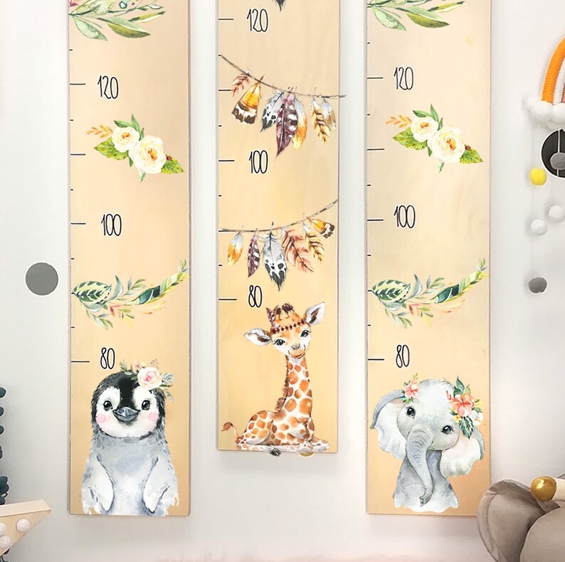 May include: Three wooden growth charts with animal illustrations. The left chart features a penguin, the middle chart features a giraffe, and the right chart features an elephant. Each chart has a floral design and a height measurement scale in inches.