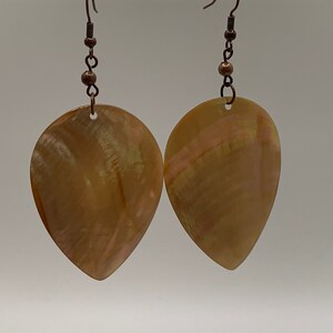 May include: A pair of teardrop-shaped earrings made from iridescent brown mother of pearl with copper wire and beads.
