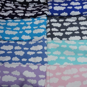 Könnte beinhalten: Ein Stapel Stoff mit einem weißen Wolkenmuster auf verschiedenen farbigen Hintergründen. Die Farben umfassen Schwarz, Lila, Blau, Grau, Hellblau, Lavendel und Rosa.