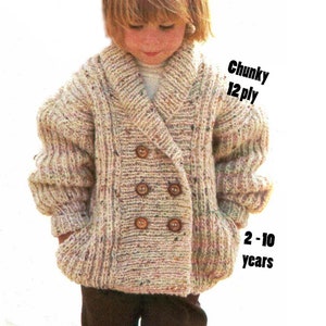 May include: A double-breasted knitted cardigan for children in a beige and brown speckled yarn. The cardigan has a wide collar and two pockets. The text "Chunky 12 ply" and "2-10 years" is visible on the image.