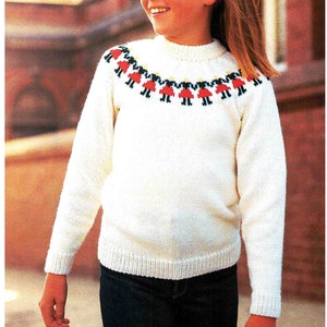 Puede incluir: Suéter blanco de punto con un patrón colorido de niñas que se toman de la mano alrededor del cuello.