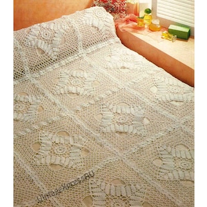 Può includere: Copriletto all'uncinetto color crema con motivo floreale. Il copriletto è composto da quadrati uniti, con una federa abbinata. Il design è intricato e dettagliato, creando un'estetica vintage.