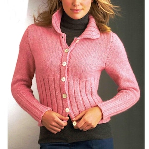 Può includere: Un cardigan rosa chiaro con bottoni. Il maglione presenta vita e polsini a coste, un ampio colletto ed è chiuso con bottoni bianchi. Le maniche sono lunghe e la maglia sembra di peso medio.
