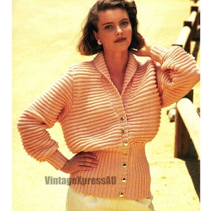 May include: A pink knitted cardigan with a ribbed texture and a V-neck. The cardigan has a button closure and a fitted waist.