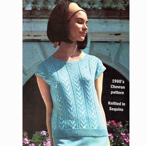 May include: A light blue knitted top with a chevron pattern, featuring sequins. The top has short sleeves and a round neckline. The text "1960's Chevron pattern Knitted in Sequins" is visible in the image.