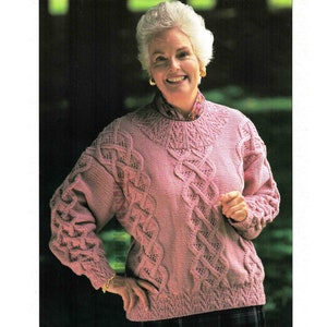May include: A pink knitted sweater with a cable knit pattern. The sweater has a round neckline and long sleeves.
