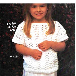 May include: A white knitted sweater with a feather and fan stitch pattern. The sweater has short sleeves and a round neckline. The text "Feather & Fan Knit" and "4 sizes" is printed on the image.