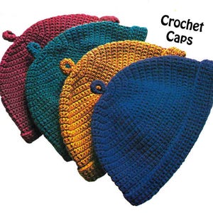 May include: Five handmade crochet caps in a range of colours: burgundy, teal, gold, and blue. Each cap features a small loop detail. The words "Crochet Caps" are written in the top right corner.