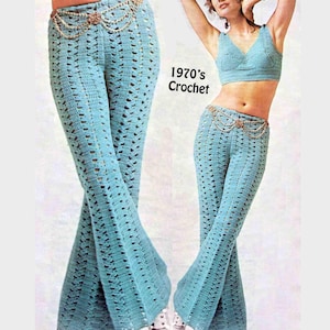 May include: Light blue crochet pants with a flared leg, paired with a matching crop top. The pants feature a decorative gold-toned chain belt. The image also includes the text "1970's Crochet".