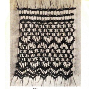 May include: A close-up of a white fabric with a black embroidered design. The design features a series of interlocking diamonds and a scalloped edge.